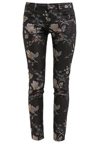 Pantalon noir slim fit avec un motif floral comprenant des fleurs beige et grises et des feuilles vertes, fermeture devant par bouton et zip.