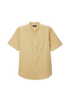 Chemise beige à manches courtes avec boutons, col mao et poche poitrine à gauche.
