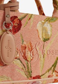 Borsa tote realizzata in tessuto intrecciato con motivo floreale in rosa pastello, con un'etichetta in pelle e dettaglio del logo impresso, dotata di manici morbidi.