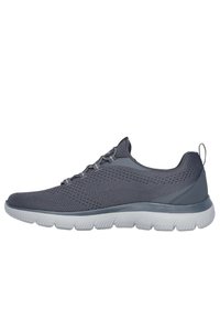 Zapato deportivo gris con un upper de malla transpirable, patrón texturizado, cordones elásticos y una suela blanca acolchada para mayor comodidad y soporte.