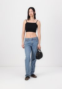 Fekete cropped tank top, világoskék trapéz farmernadrág, leopárdmintás balettcipők és egy kis fekete táska, steppelt textúrával.