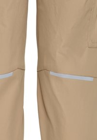 Μπεζ παντελόνι με οριζόντια ανακλαστική ταινία πάνω από το γόνατο και ορατή ραμμένη τσέπη στο δεξί πόδι.