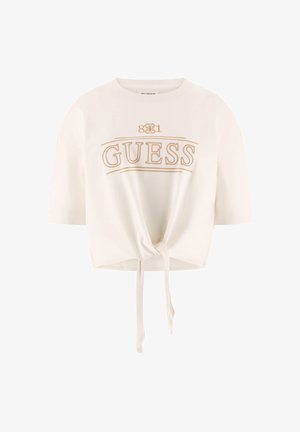 Tricou alb, scurt, din bumbac moale, cu mâneci scurte, prezintă un logo auriu "GUESS" și un detaliu de nod frontal la tiv.