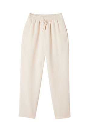 Beige lounge pants with a relaxed fit, elastic waistband, drawstring, and side pockets. Made from a soft, textured fabric.