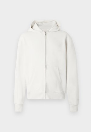 Fehér, cipzáros kapucnis pulóver puha anyagból, húzózsinórral ellátott kapucnival, elülső zsebekkel, valamint bordázott mandzsettákkal és aljjal a részletgazdagság érdekében.