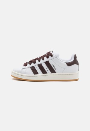 White low-top sneaker with brown stripes, brown laces, "CAMPUS" text, and gum sole on a white background.