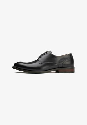Black leather dress shoe with a rounded toe, lace-up design, and a subtle textured finish. Features a low brown heel.