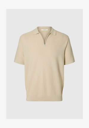 Polo beige à manches courtes avec un motif finement texturé et une courte fermeture éclair au col.