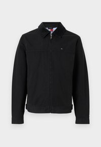 Μαύρο μπουφάν με γιακά, φερμουάρ στο μπροστινό μέρος και πλαϊνές τσέπες. Κατασκευασμένο από λείο ύφασμα, με μικρό λογότυπο στο στήθος.