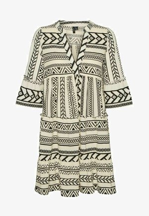 Czarna i biała sukienka w wzory z dekoltem w serek, rozkloszowanymi rękawami i warstwowym wykończeniem. Wykonana z lekkiego materiału z geometrycznymi motywami.