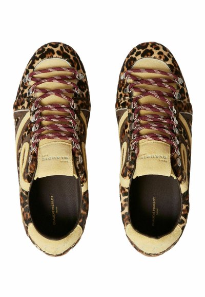 Un par de zapatillas de leopardo con acentos de ante beige y cordones burdeos, vistas desde arriba sobre un fondo blanco.