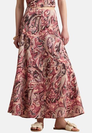 Falda fluida de talle alto con patrón floral abstracto en rosa y beige, combinada con un crop top a juego y sandalias planas beige con punta abierta.