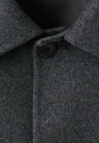 Abrigo de lana gris con un collar estructurado, cierre de botón negro y una textura sutil. La vista en primer plano destaca los detalles de la tela y la costura.