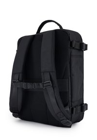 Črn nahrbtnik z teksturiranim mrežastim hrbtom, nastavljivimi oblazinjenimi trakovi in kovinskimi zaponkami. Ima poenostavljeno pravokotno obliko.