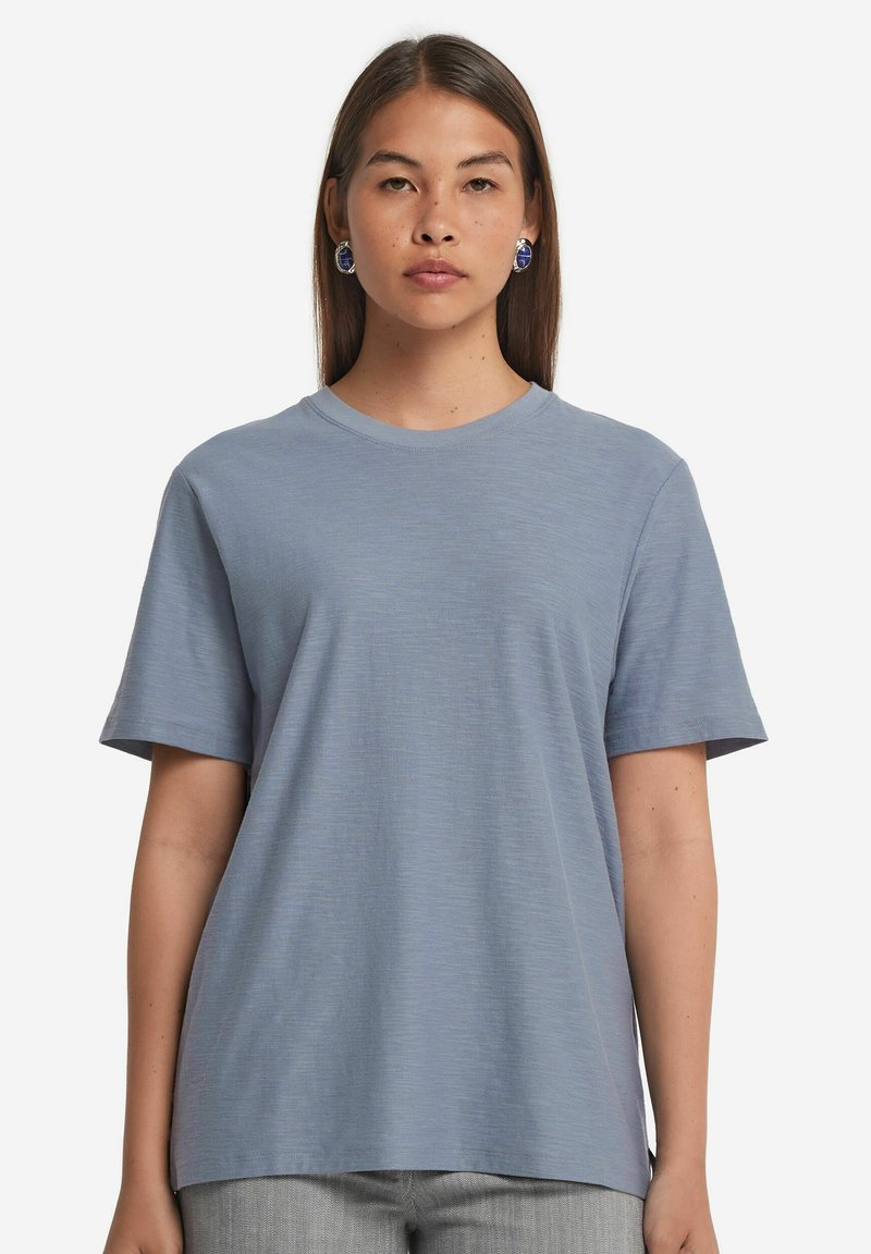 Ljusblå t-shirt med kort ärm, tillverkad av mjukt tyg, med rund halsringning och en avslappnad passform med subtil textur.