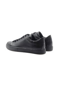 Baskets en cuir noir avec une texture lisse, bout arrondi, design à lacets et semelle en caoutchouc. Présente des accents noirs minimalistes.