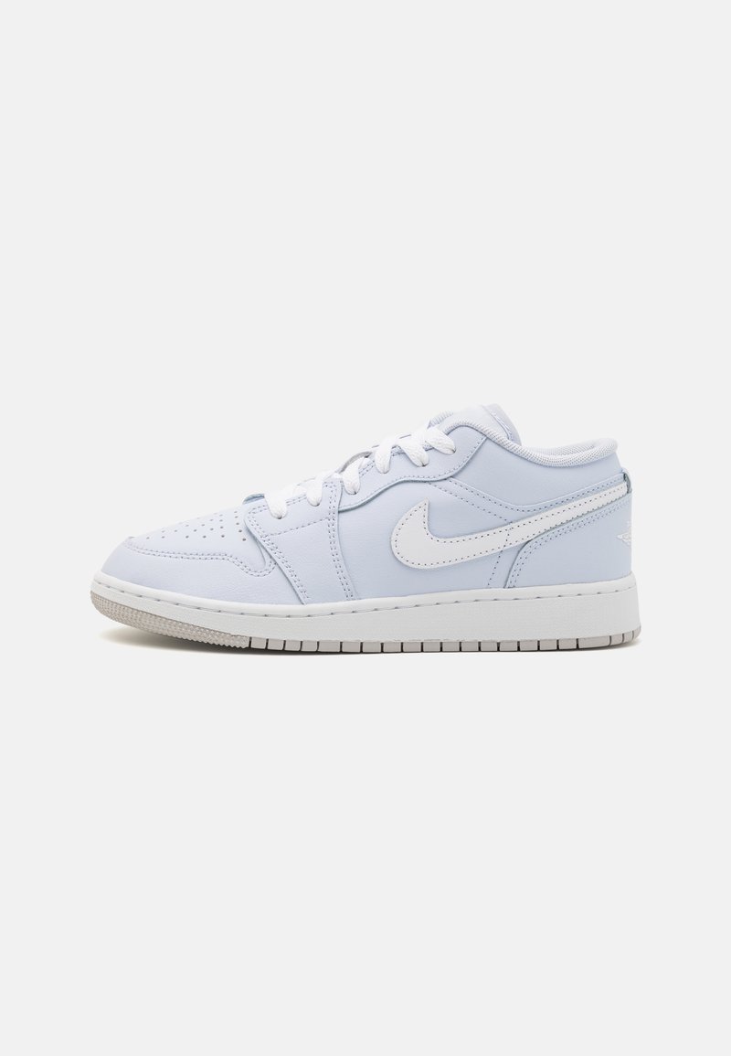 Baskets basses blanches et gris clair Nike avec fermeture à lacets et bout perforé, vues de côté sur fond uni.