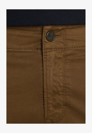 Brown cotton trousers with a smooth texture, featuring a metal button and stitching near the waist, with a navy ribbed waistband above.