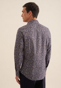 Katoenen langemouwen shirt met een donker bloemenpatroon met kleine blauwe en roze bloemen op een marineblauwe achtergrond, klassieke kraag en ronde zoom.
