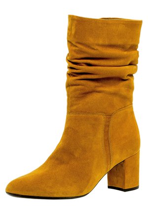 Gelbe Wildleder-Ankle-Boots mit einem lässigen Design, spitzem Zehenbereich und klobigem Absatz. Verfügt über eine weiche Textur und minimale Nähdetails.