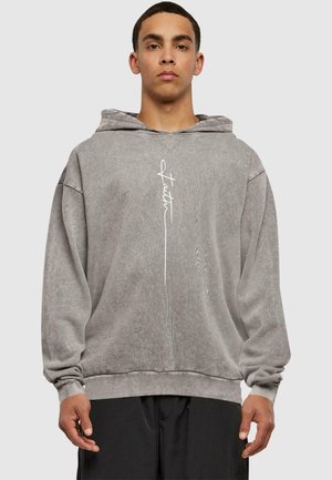 Grå hætte sweatshirt lavet af blødt stof, med en lomme foran, oversized pasform og hvid "faith" tekstaccent på brystet.
