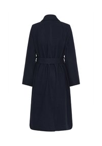 Abrigo largo de color navy en un material suave, con una cintura ceñida por un cinturón, mangas anchas y un clásico cuello. Textura suave sin patrones visibles.