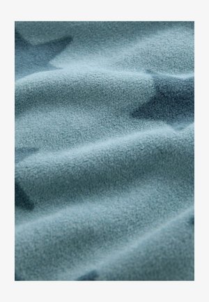 Vilnonis audinys švelniai, nuslopintai mėlynai žaliai spalvoje, su subtiliais žvaigždžių raštais. Tekstūra lygi ir šiek tiek puri.