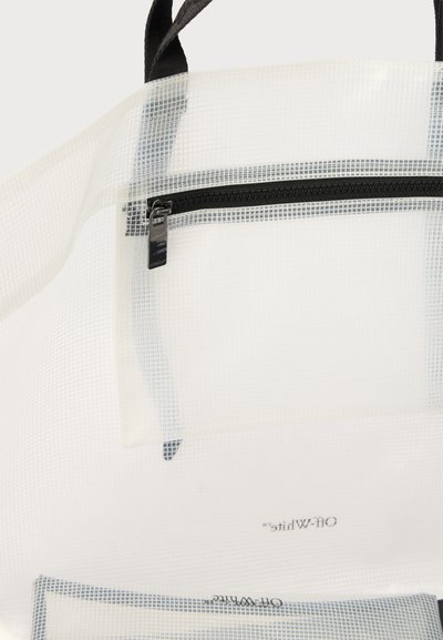 Διαφανής λευκή τσάντα tote με μαύρες λαβές και μπροστινή τσέπη με φερμουάρ.