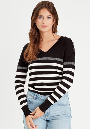Maglione a righe bianche e nere con scollatura a V, accentuato da una striscia argento e bottoni decorativi sulla spalla. Tessuto in maglia morbida. Vestibilità casual.