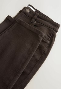Jeans skinny neri realizzati in tessuto misto cotone, con chiusura a bottone, passanti per cintura e una superficie liscia con orli cuciti.