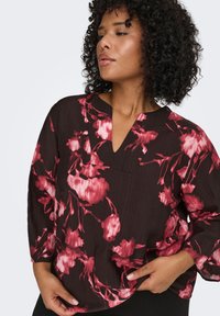 Dark brown blouse with pink floral pattern, V-neckline, three-quarter sleeves, textured cotton fabric, and relaxed fit.
