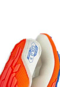 Gant de soccer orange et blanc avec un motif de prise texturé, présentant des accents bleus et une étiquette marquée "GRIP GOLD X" par Reusch.