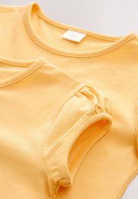 Gelbe Baumwoll-T-Shirts, eines mit rundem Ausschnitt und das andere mit gerafften kurzen Ärmeln, zeigen eine glatte Textur und ein schlichtes Design.