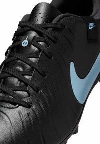 Black soccer cleat with a textured leather upper, featuring a light blue Nike Swoosh, black laces, and small ventilation holes on the tongue.