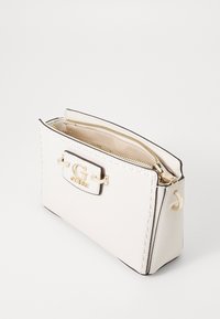 Borsa in pelle bianca con chiusura a zip, caratterizzata da un accento del logo dorato e dettagli di cucitura. Forma quadrata con una finitura testurizzata.
