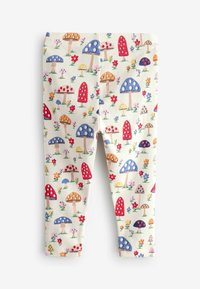 Leggings a coste con uno sfondo crema chiaro e motivi colorati di funghi e fiori in rosso, blu, giallo e verde.