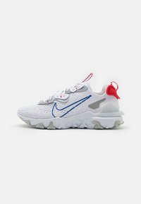 Zapatilla deportiva blanca con parte superior de malla, logo de swoosh azul, acentos en rojo y gris, suela texturizada, cuello acolchado y una lengüeta en el talón.