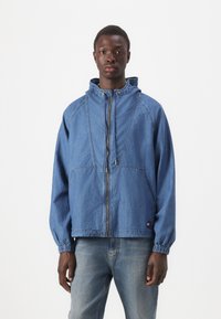 Blå denimjakke med hette, frontglidelås, elastiske mansjetter og to store frontlommer, med kontraststingdetaljer.