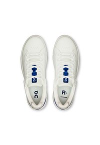 Baskets blanches avec une tige en cuir lisse, des accents bleus, un orteil perforé et un système de laçage. Présente des détails de logo sur la languette et le côté.