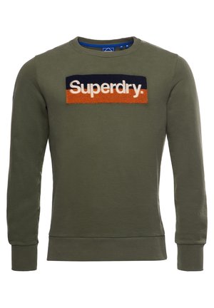 Sweat-shirt à manches longues vert olive avec poignets et ourlet côtelés, présentant un patch bleu marine et orange avec le texte blanc "Superdry." sur la poitrine.