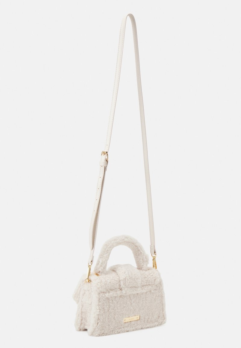 Petit sac à main blanc texturé avec poignée courte et longue bandoulière réglable, de forme rectangulaire avec des détails en métal doré.