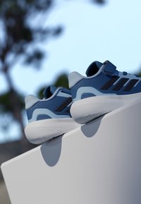 Sinised spordijalatsid tekstureeritud võrgust pealsega, helesiniste detailide ja valge Cloudfoam tallaga, millel on kolm musta triipu ja takjakinnitus.