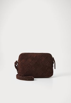 Petit sac bandoulière en daim marron foncé avec motif tissé et bandoulière réglable sur fond blanc uni.