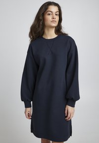 Marineblaues Sweatshirtkleid, lange Ärmel mit gerafften Bündchen, lockere Passform, runder Halsausschnitt, seitliche Schlitze am Saum, weicher Stoff.