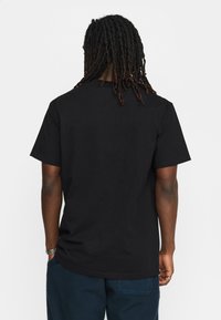 Zwarte katoenen t-shirt met een klassieke pasvorm, korte mouwen en geen zichtbare grafische elementen. Gladde textuur en eenvoudig ontwerp.