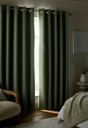 Dunkelgrüne Verdunkelungsvorhänge teilweise geöffnet, Licht scheint durch das Fenster in einem gemütlichen Schlafzimmer.