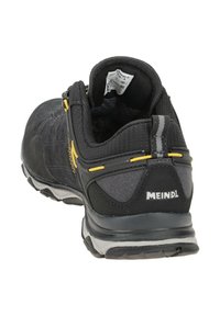 Černá turistická bota se svrškem z usně a textilu, s žlutými akcenty, polstrovaným límcem a texturovanou gumovou podrážkou.