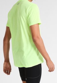 Camiseta deportiva de hombre de manga corta en verde neón, fabricada en tejido ligero, con cuello redondo y un sutil patrón texturizado.