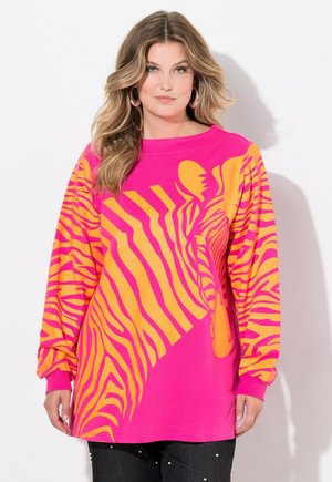 Langemouw T-shirt in oversized model, felroze met een groot geel zebrapatroon. Zachte katoen met geribde manchetten.