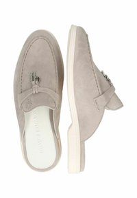 Ljusgrå mocka slip-on skor med tydlig sömnadsdetaljering, en silverfärgad logotyp och en vit gummisula. Slät inredningsfoder.